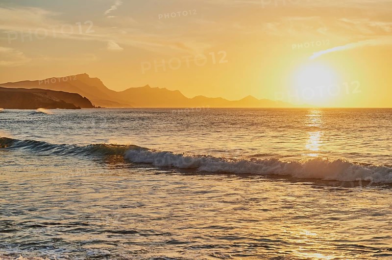 Beach Playa de la Pared with rocky coast at sunset