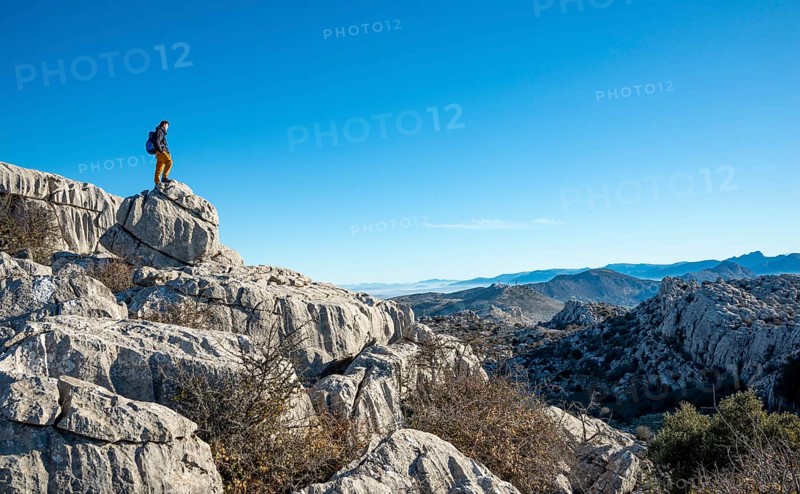 Young man standing on rocks and looking into the distance