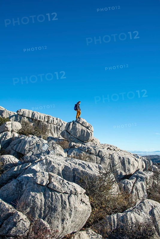 Young man standing on rocks and looking into the distance