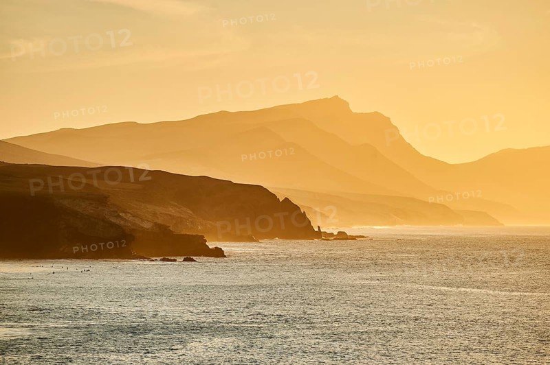 Beach Playa de la Pared with rocky coast at sunset