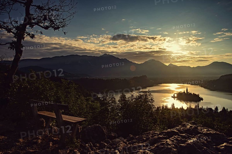 A bench for lovers with a view of the rising sun on Lake Bled