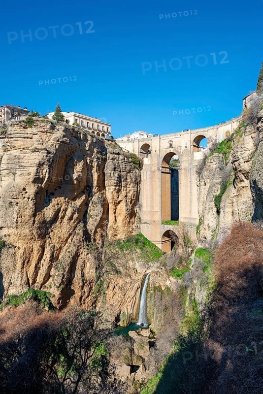 Bridge Puente Nuevo with waterfall at steep cliffs