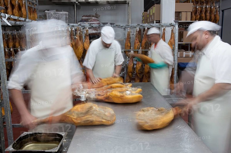 Employees select pieces from Jamon Serrano for packaging
