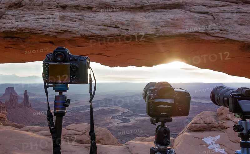 Cameras with view through Mesa Arch at sunrise