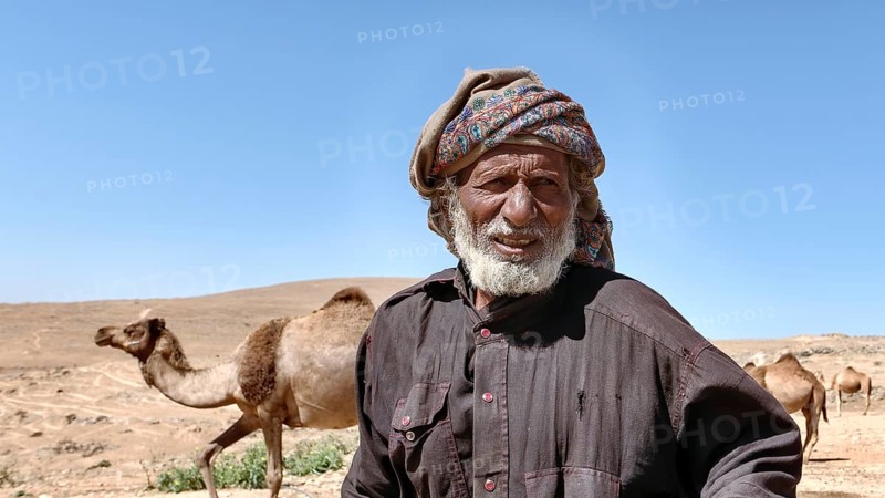 Camel breeder with camels in the mountains north of Salalah