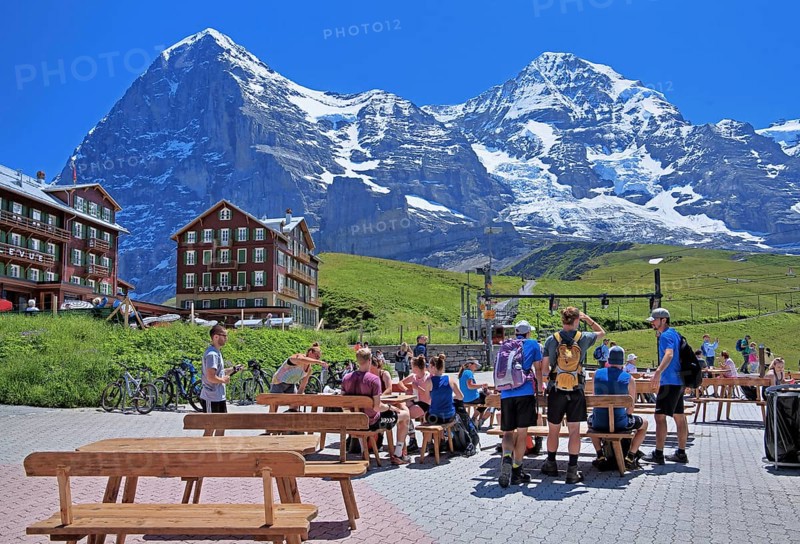 Tourists and hikers on Kleine Scheidegg in front of the Eiger and Moench