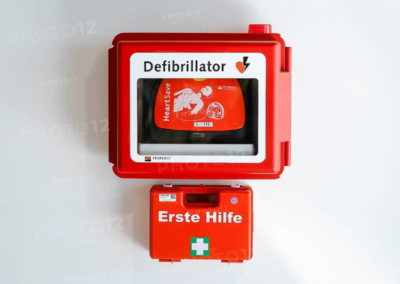 Defibrillator and first aid kit hanging on a wall in public space at Duesseldorf Airport