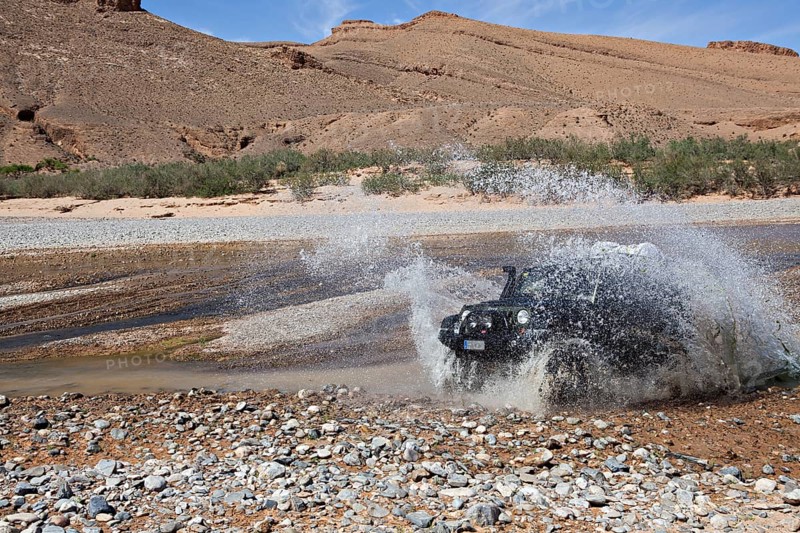 Off-road vehicle crosses a river in the Middle Atlas