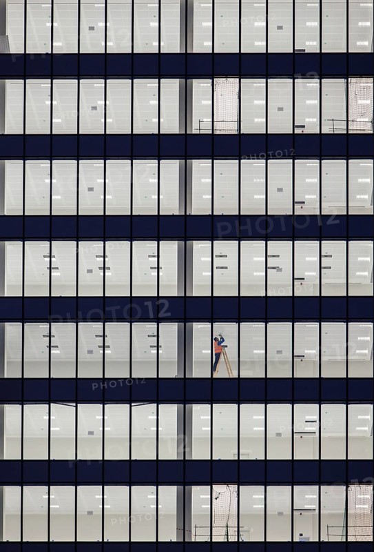 Worker in the facade of an office building on the outskirts of Madrid