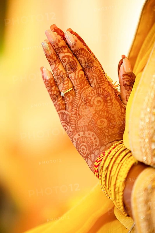 Hindu Bride crossing hands painted with henna for prayer on wedding eve
