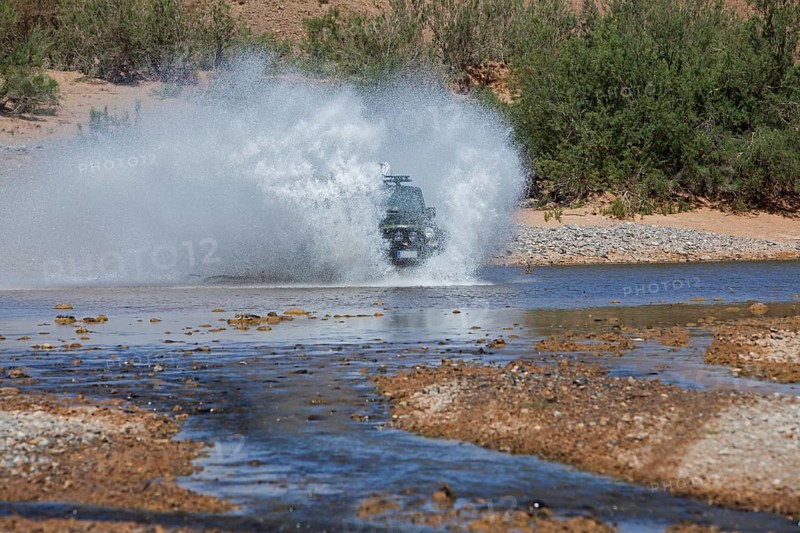 Off-road vehicle crosses a river in the Middle Atlas