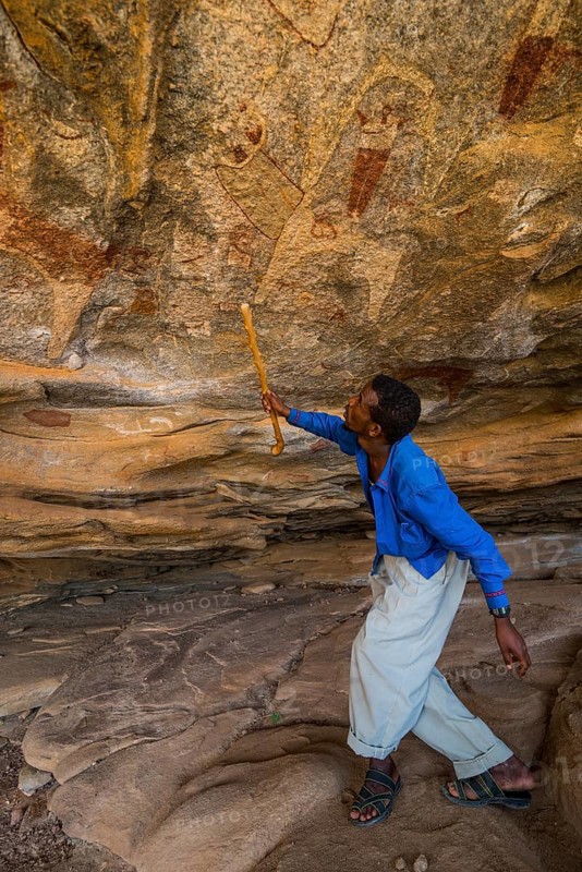 Guide pointing at cave paintings in Laas Geel caves