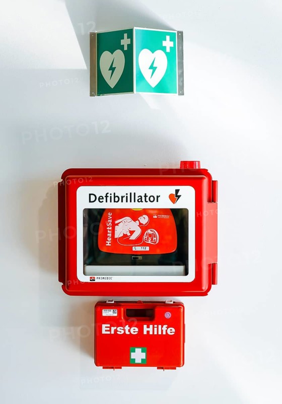 Defibrillator and first aid kit hanging on a wall in public space at Duesseldorf Airport