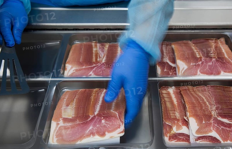 Cured ham being packaged