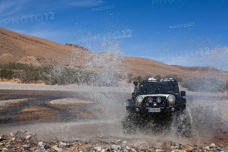 Off-road vehicle crosses a river in the Middle Atlas