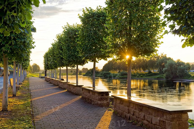 Sunset at the Weser bank with sunrays through trees