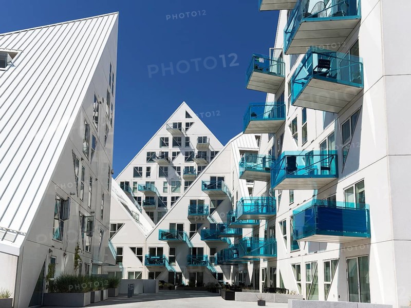 White residential complex with turquoise balconies against a blue sky