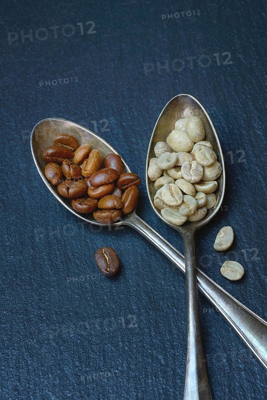 Green coffee and roasted coffee beans in spoon