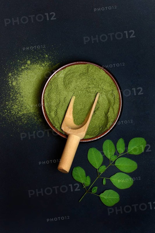 Moringa powder in bowl and Moringa leaves