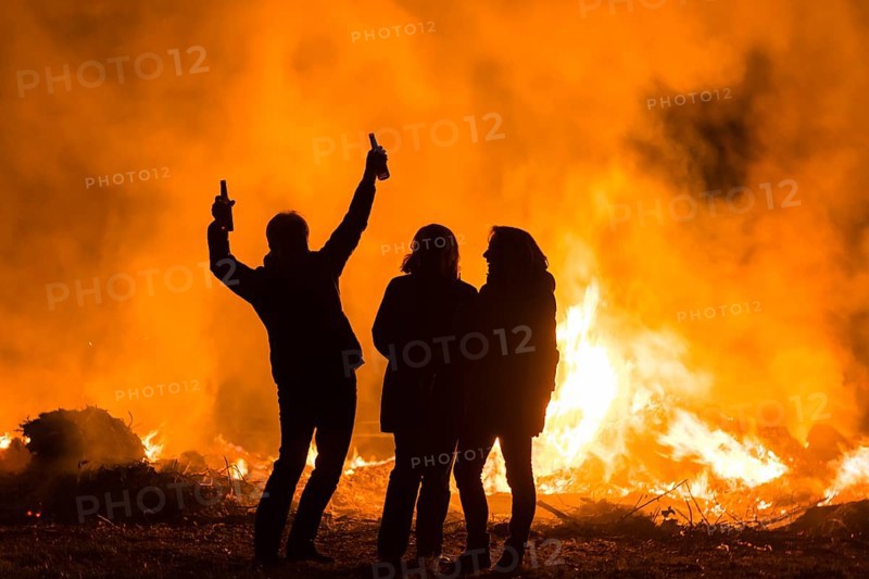 Silhouettes of three people at an Easter fire