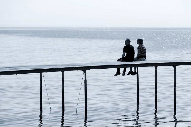 Couple sitting on bathing jetty
