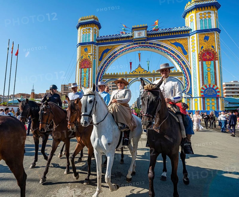 Riders on decorated horses in traditional dress in front of the entrance gate