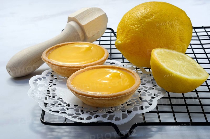 Lemon tartlets and lemon on a cake rack