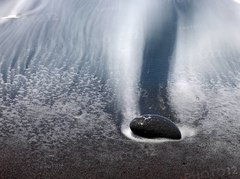 Black stones and sand with run-off water