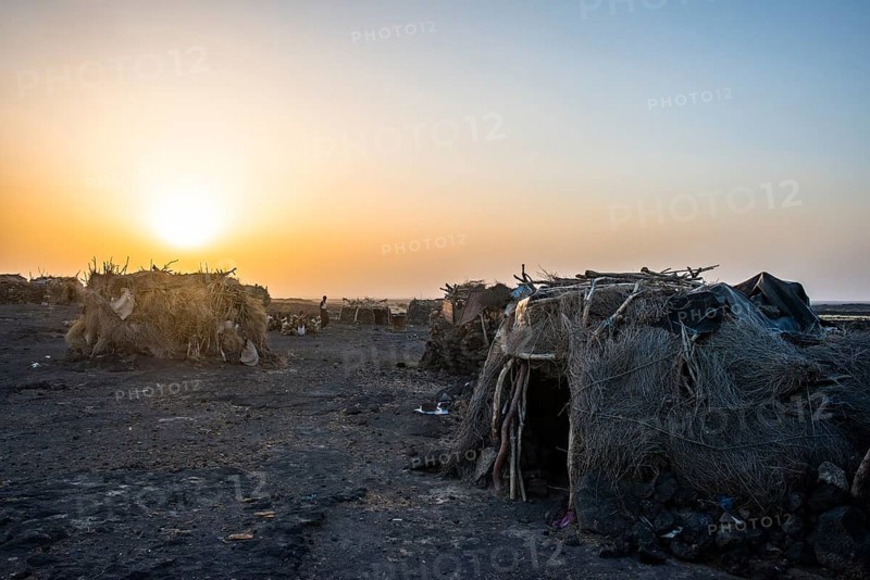 Village with huts of the Afar nomads at sunset