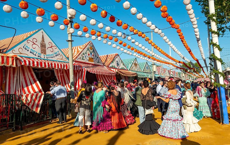 Celebrating Spaniards in traditional dress in front of marquees