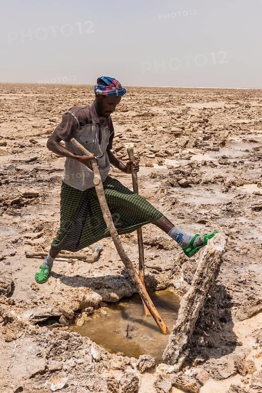 Afar nomad cutting and lifting out salt plates