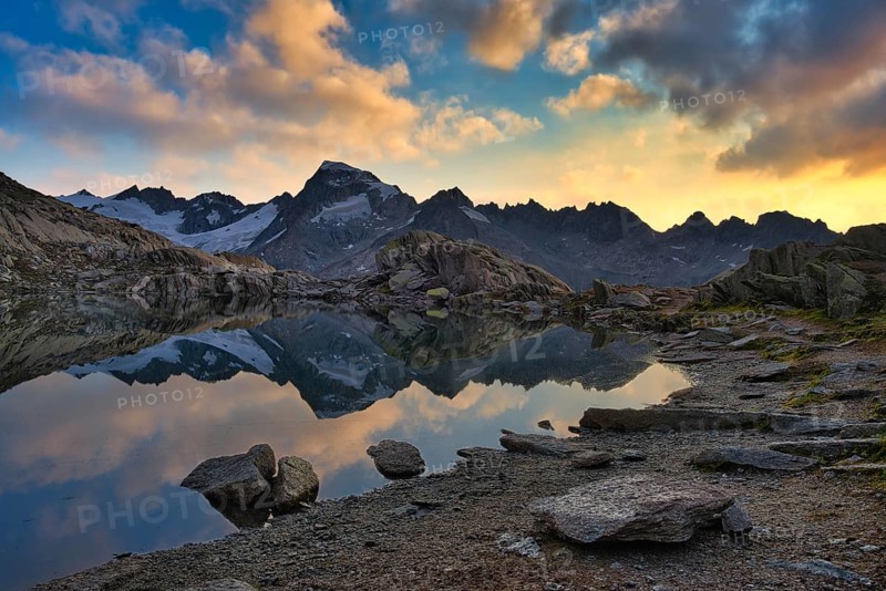 Graetlisee with reflection of the mountains and clouds in the morning light