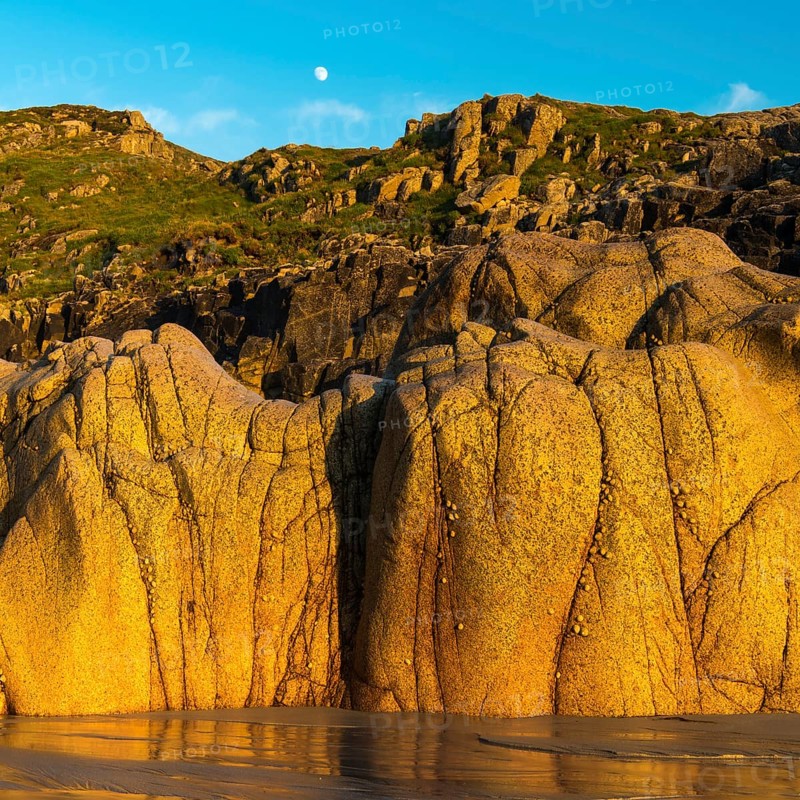 Moon above the rocky coast at Porth Nanven