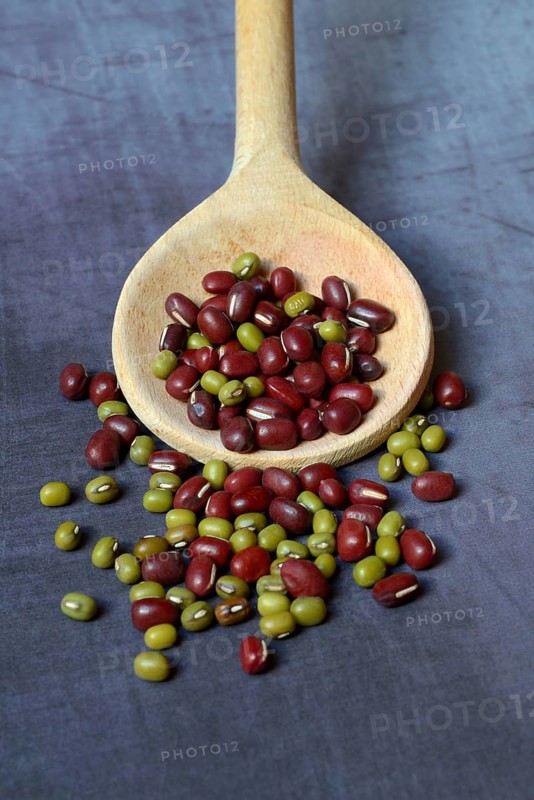 Red beans and green mung beans on wooden spoon