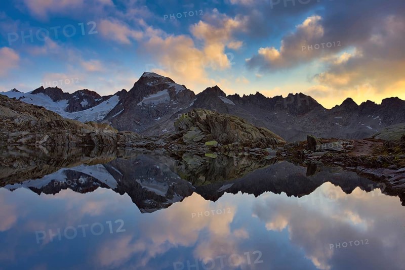 Graetlisee with reflection of the mountains and clouds in the morning light