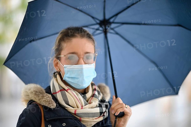 Woman with face mask and umbrella