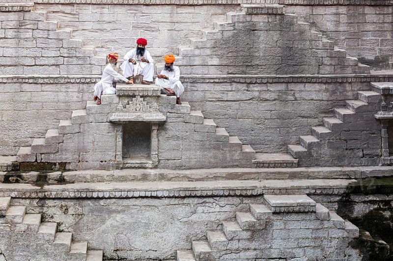 Three men playing cards at the stepwell Toorji Ka Jhalra