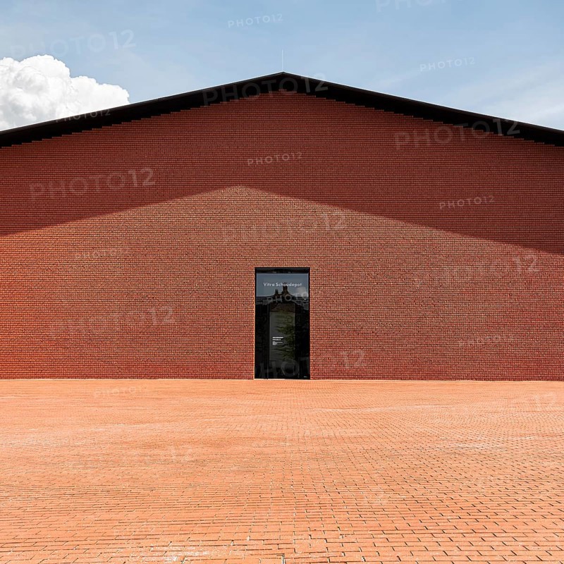 Windowless red brick building in the shape of a warehouse