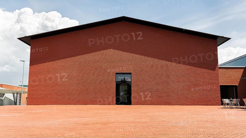 Windowless red brick building in the shape of a warehouse