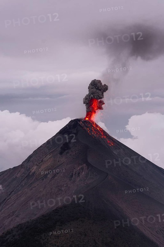 Glowing lava and smoke spitting volcano