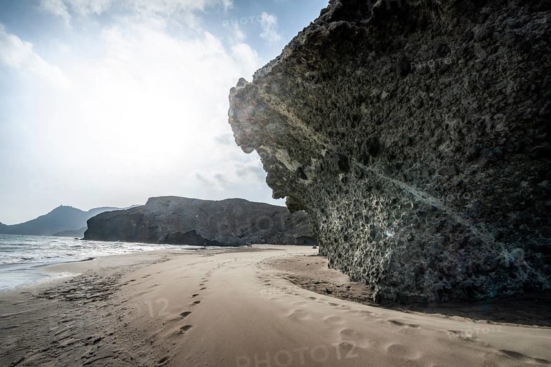 Petrified lava tongues and rocky coast at the beach Playa del Monsul
