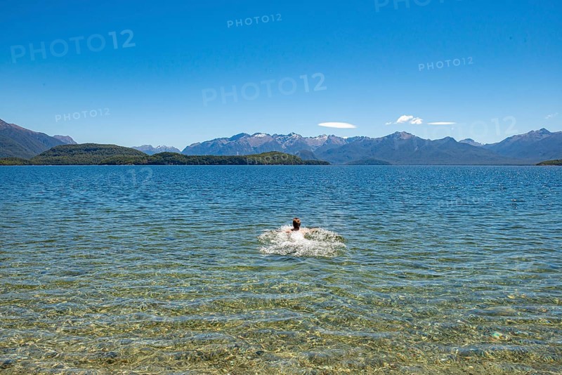 Young man bathes in the lake