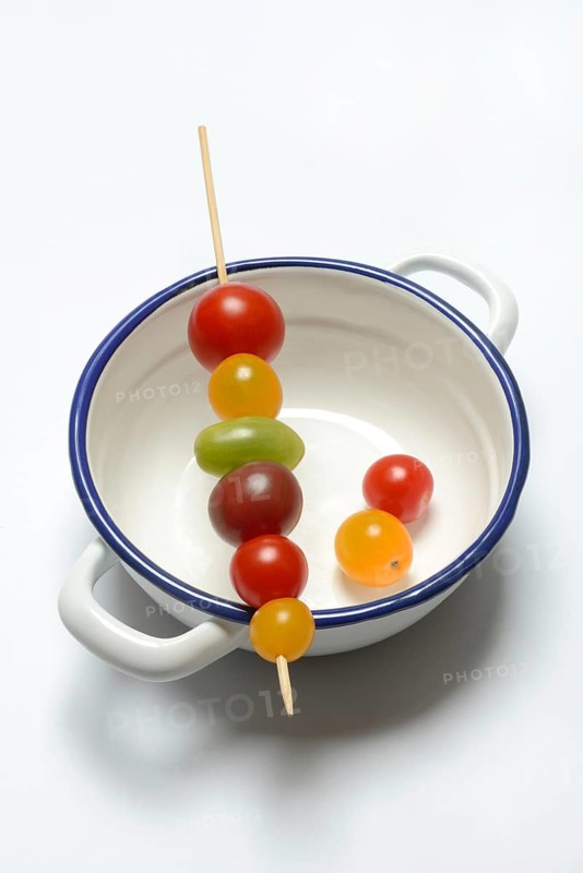 Various cherry tomatoes on wooden skewers on a bowl