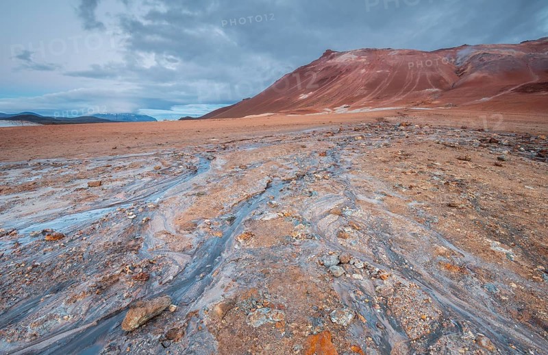 Water from a hot spring flows over the red plain