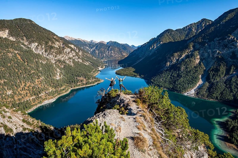 Two hikers stretch arms in the air