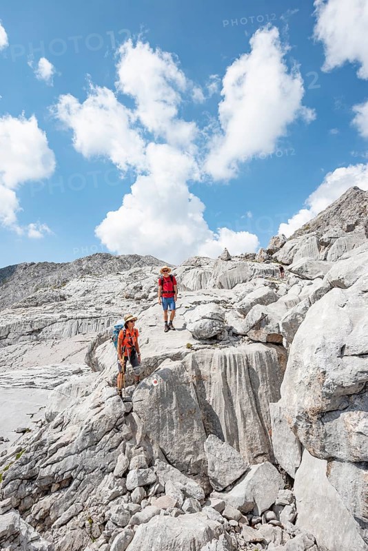 Two hikers in a landscape of washed out karst rocks