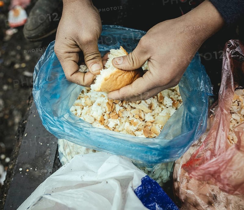 Refugee plucks bread for a meal in a shelter for refugees