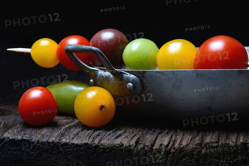 Various cherry tomatoes on wooden skewers on peel
