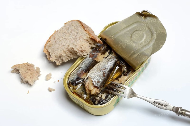 Sardines in opened tin with fork