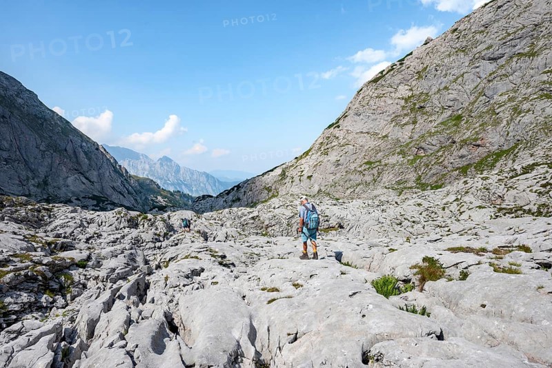 Hikers in a landscape of washed out karst rocks